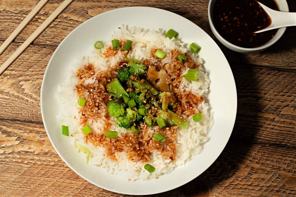 top down photo of a bowl of rice and broccoli with 10 minute stir fry sauce