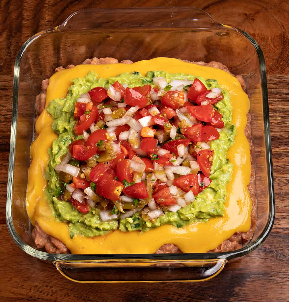 Top down photo of my vegan 7 layer dip topped with homemade pico de gallo