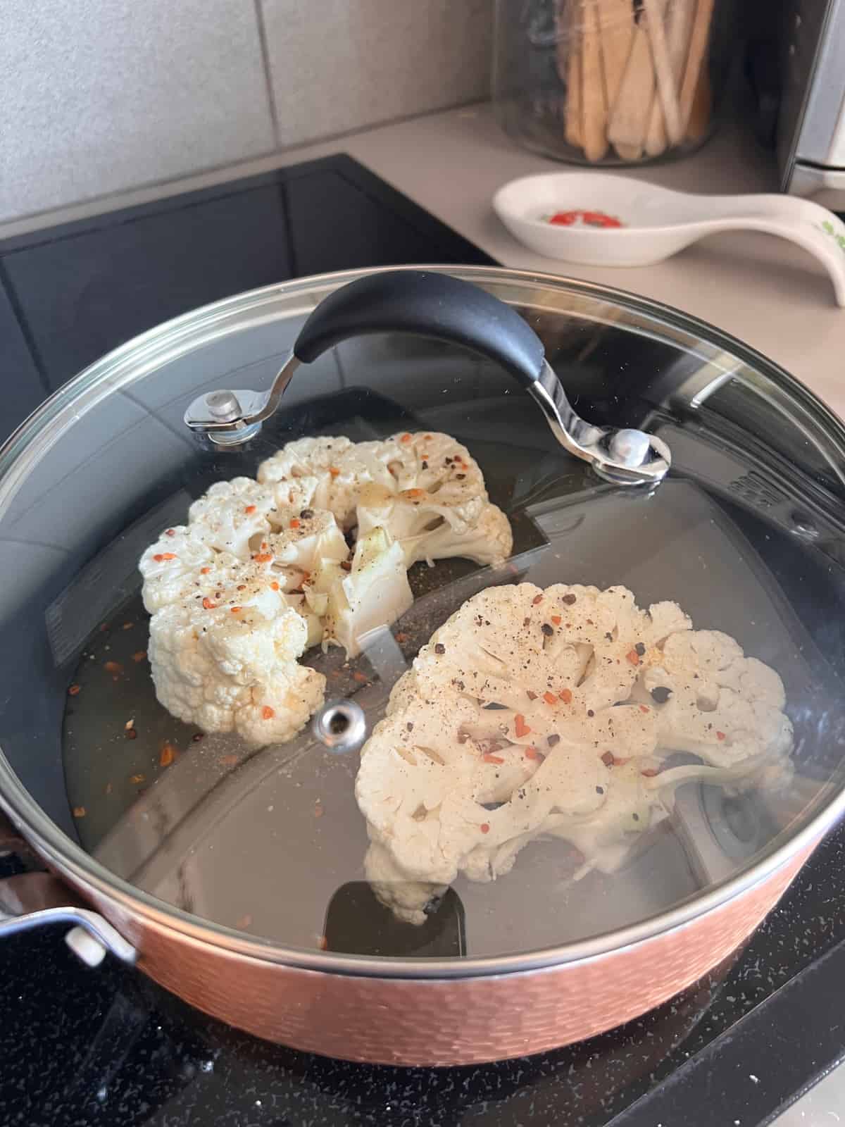 covered pan of cauliflower steaks