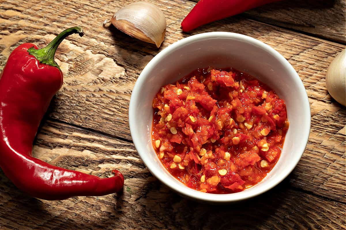 top down look at a bowl of chili garlic sauce and a Red Fresno Chile