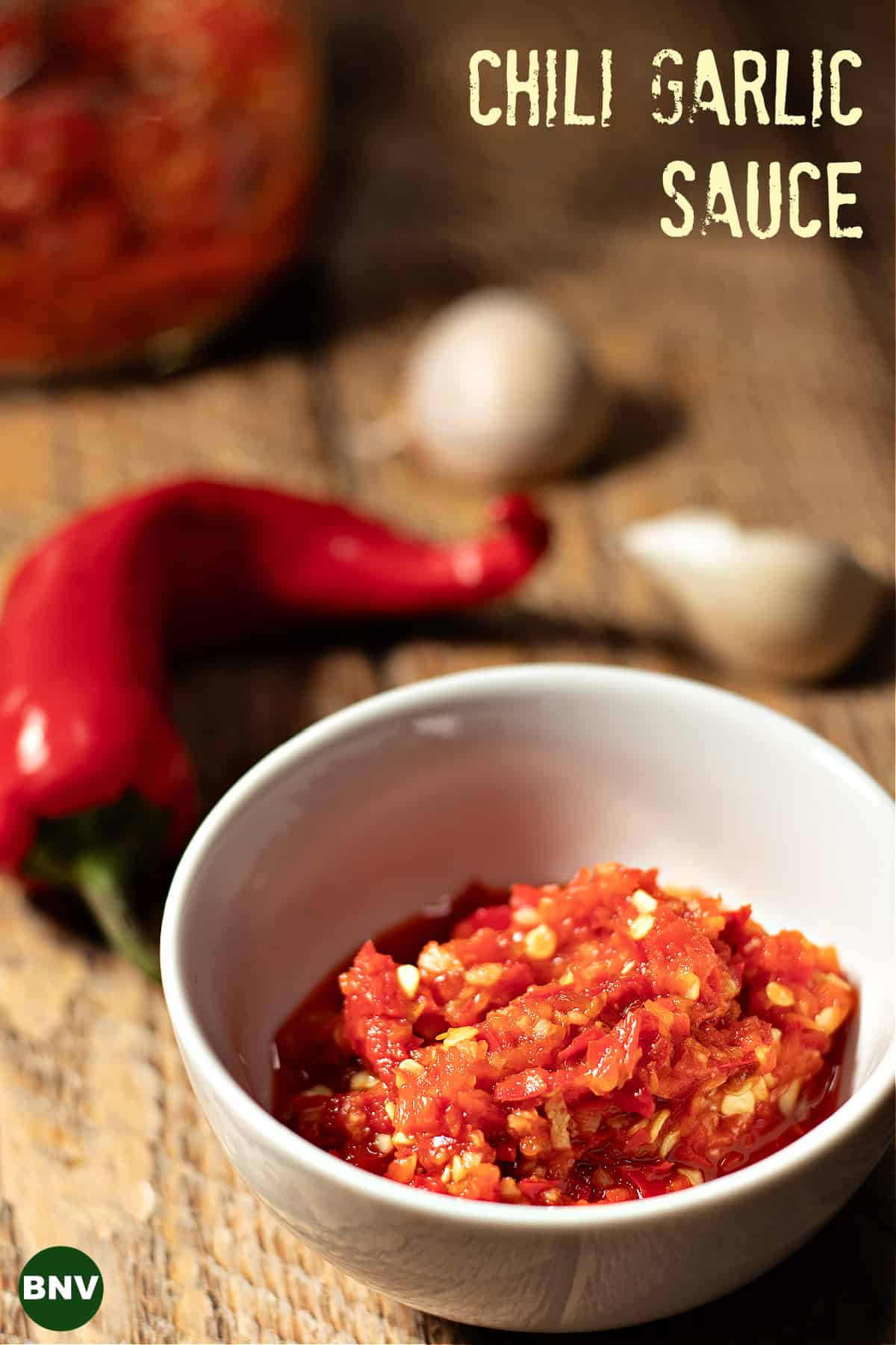 bowl of copycat chili garlic sauce next to a Red Fresno Chile pepper