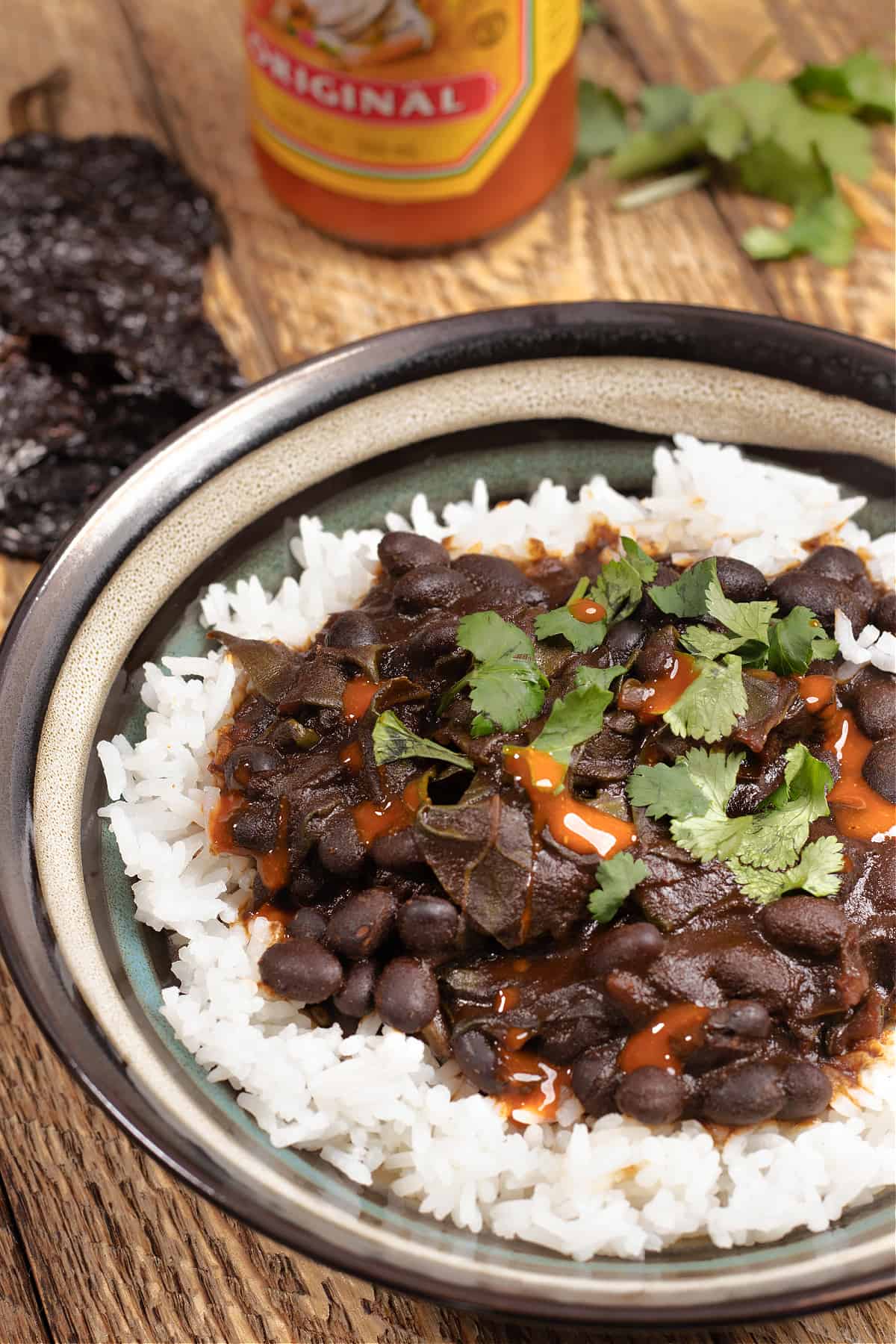 bowl of rice covered in Mexican beans and greens