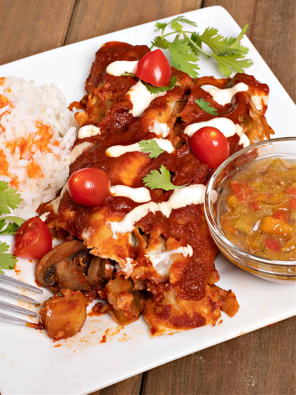 a plate of vegan potato enchiladas, rice, and green Chile sauce