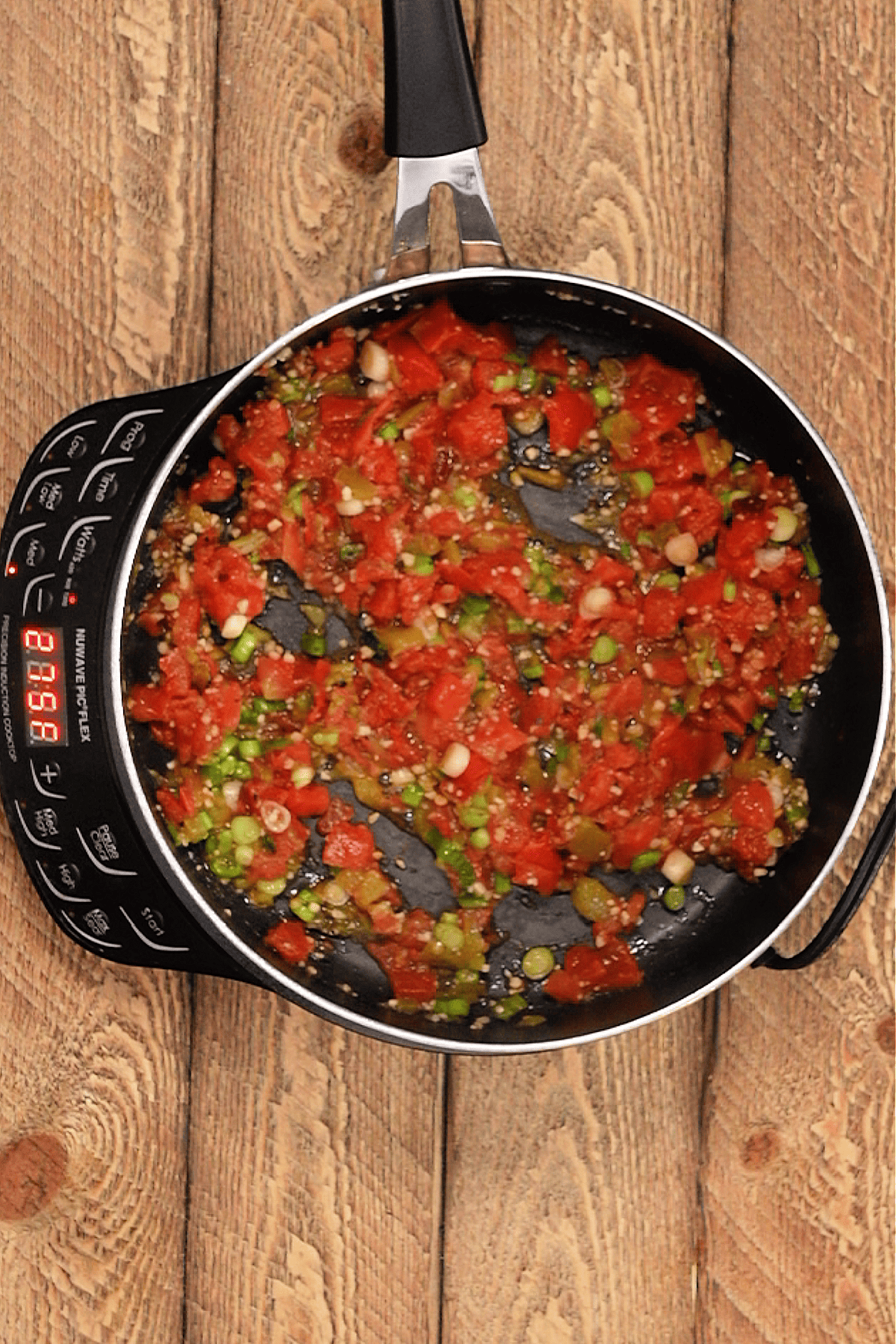 saute pan with garlic, green onions, cumin, chipotle, rotten tomatoes, and green Chile