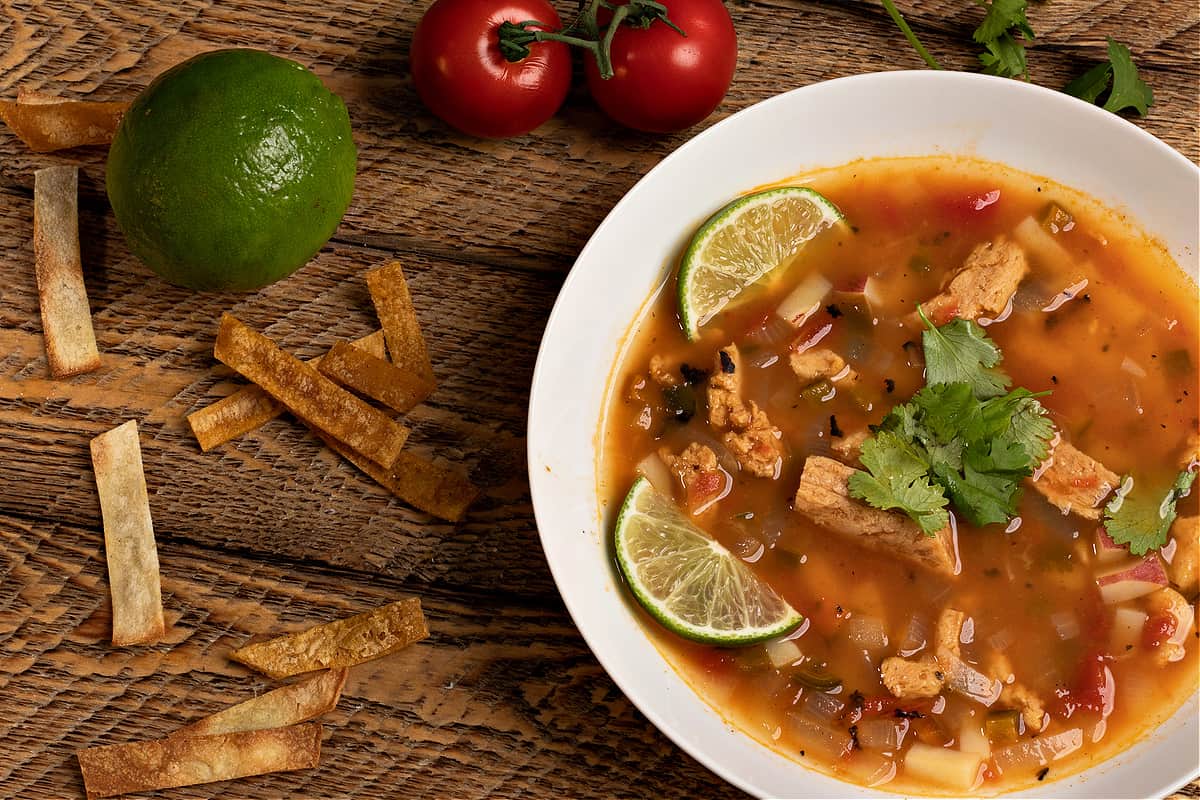 bowl of Sopa de Lima with tortilla strips 