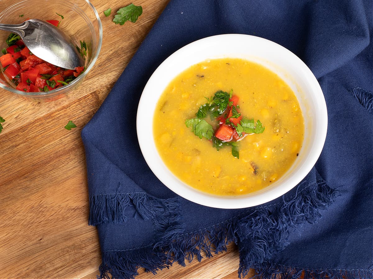 Bowl of southwestern squash and corn soup with a ramekin of red pepper relish