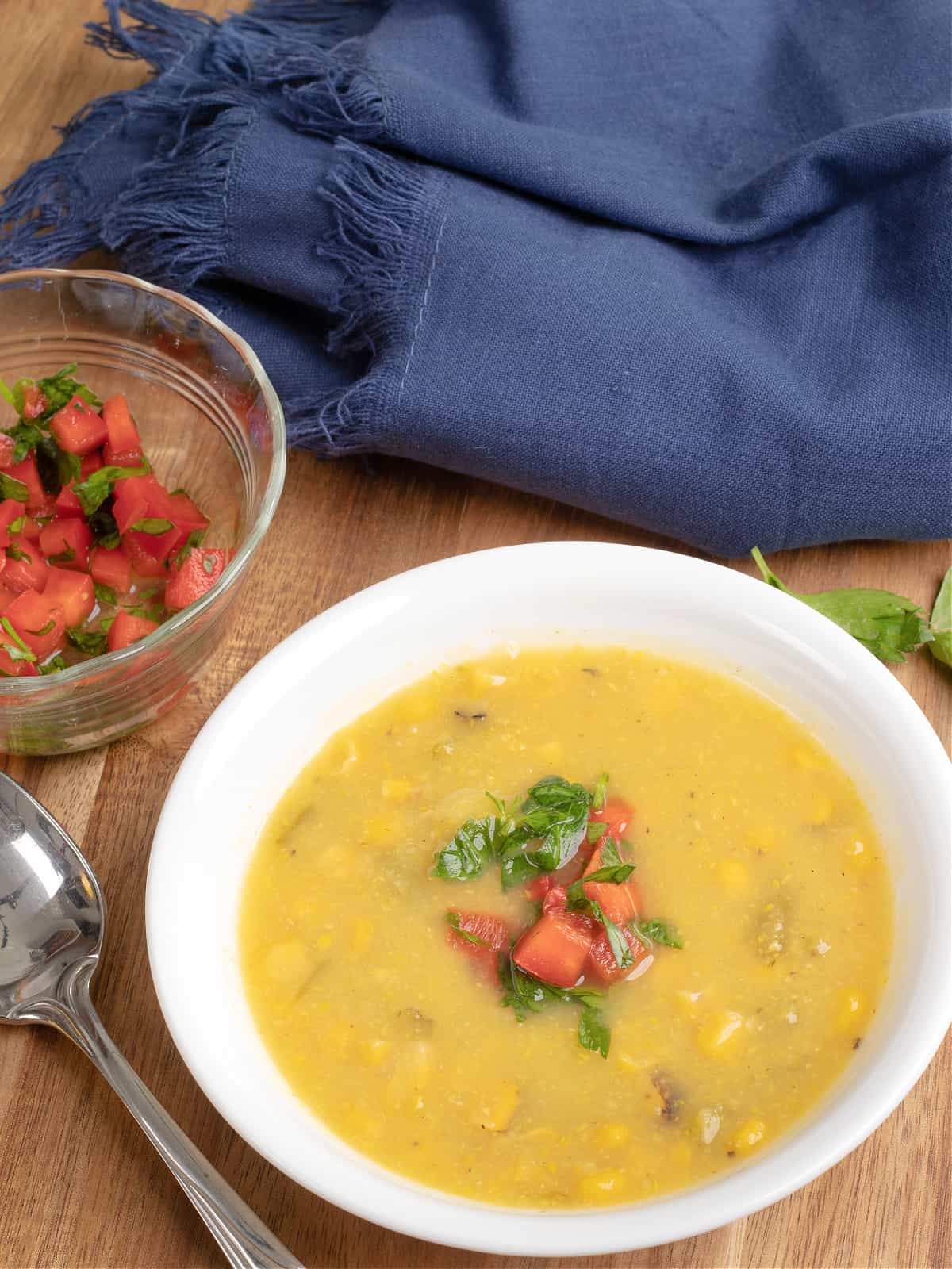 Bowl of southwestern squash and corn soup with a ramekin of red pepper relish