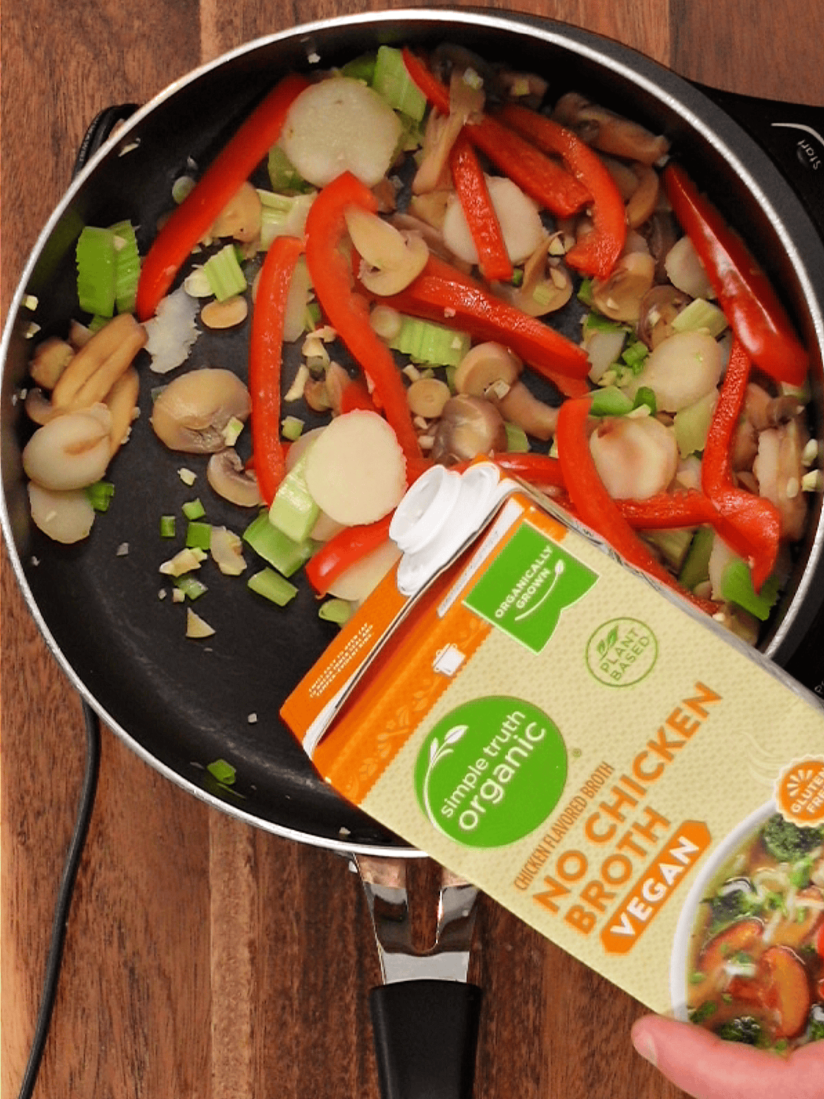 adding no-chicken broth to a vegan cashew chicken stir fry