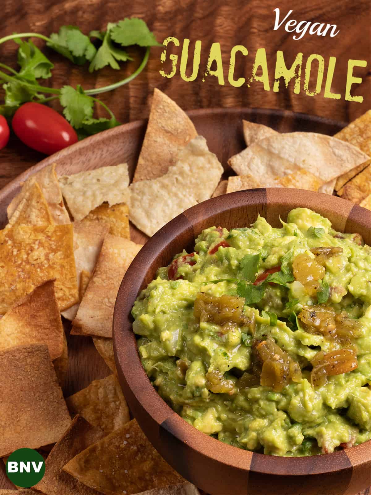 overhead photo of a platter o tortilla chips and a bowl of vegan guacamole
